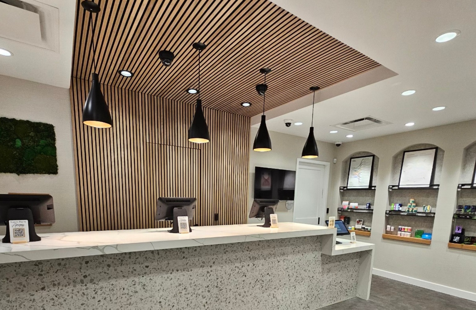 Interior shot of Blue Oak Dispensary featuring the check out counter with vertical wood tiled background feature