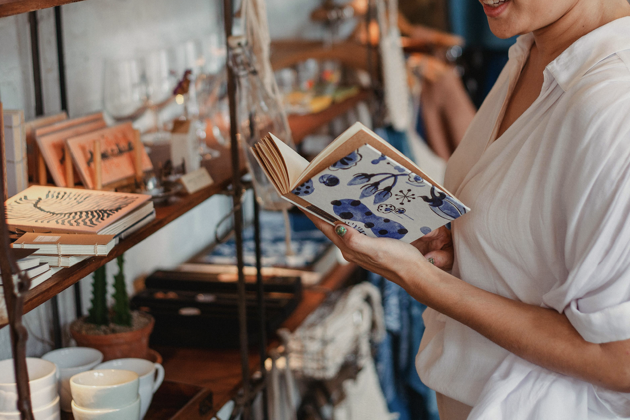 Woman holding a book, shopping in Bloomfield.