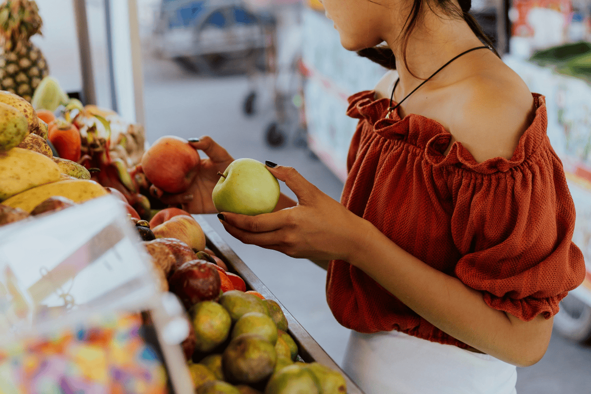 Woman holding an apple at a New Jersey farmers market.