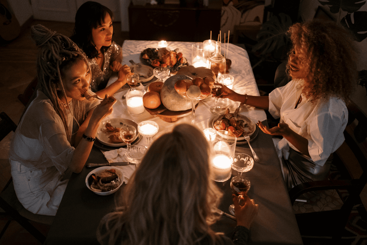 Female friends eating at a friends giving celebration.