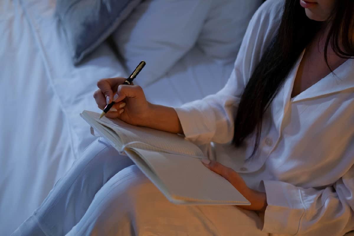 Woman writing in her cannabis tracking journal.